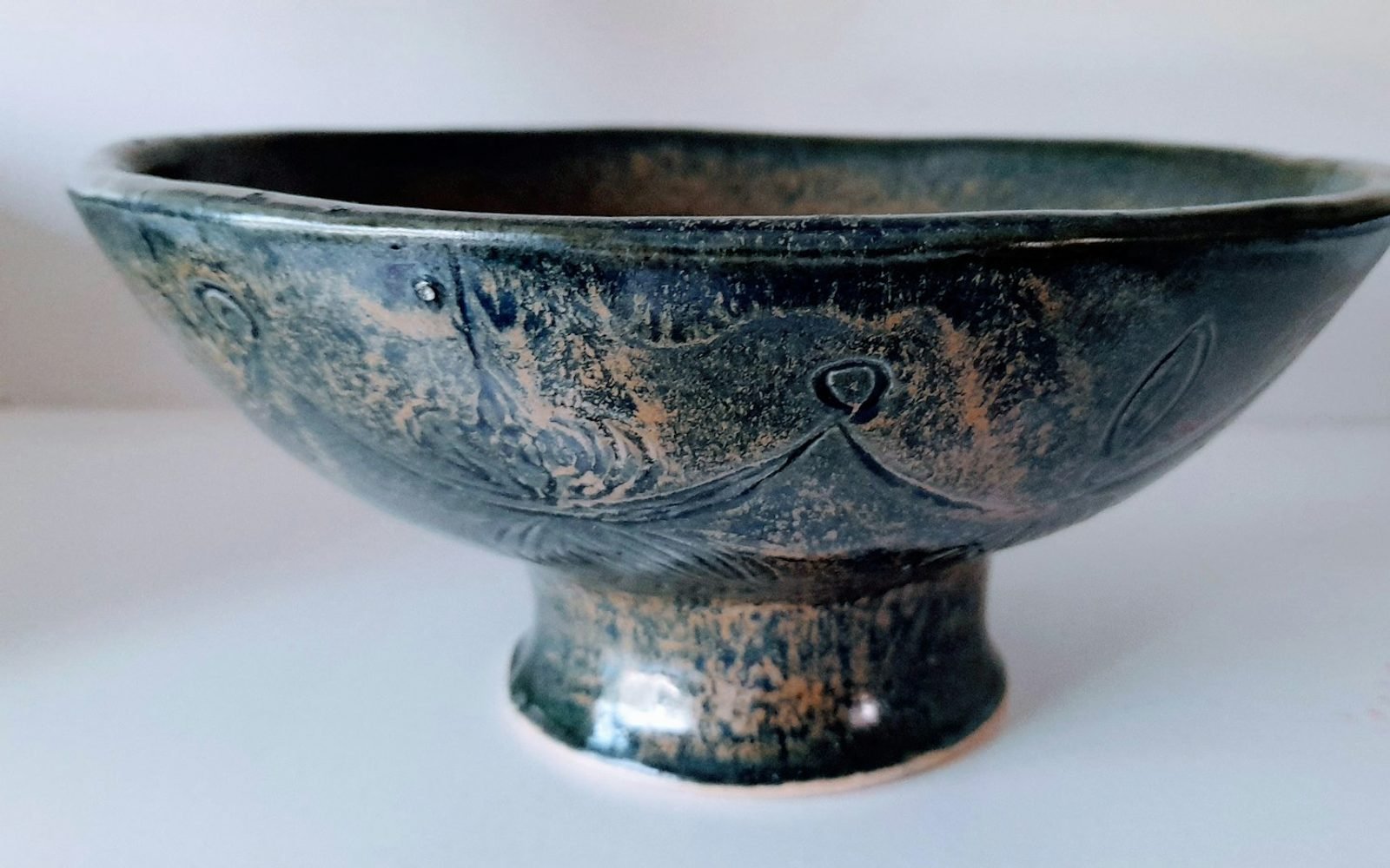green tea leaves beside a small bowl